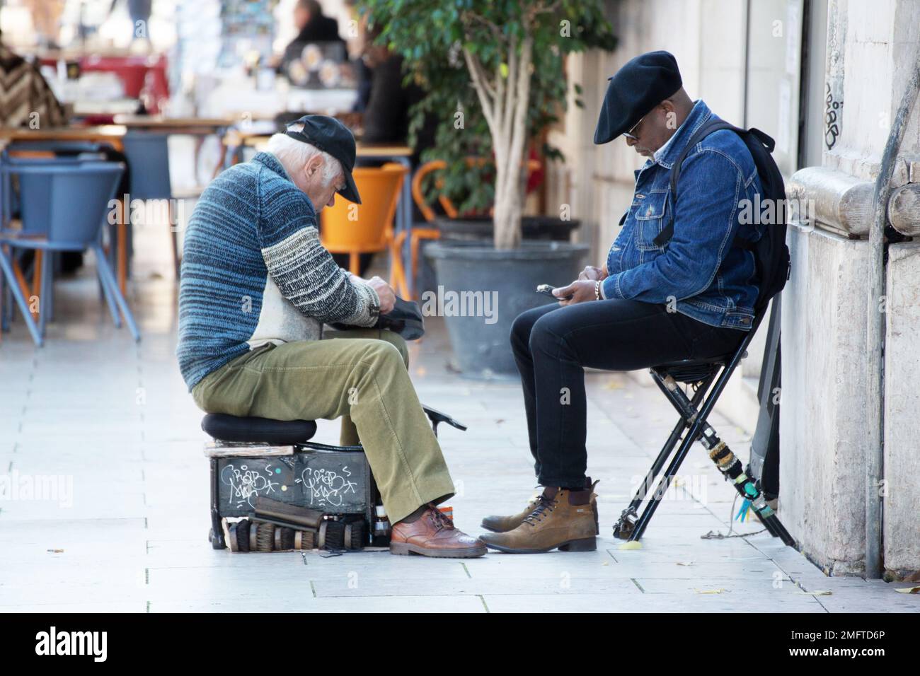 L'uomo anziano pulisce le scarpe per le strade Foto Stock