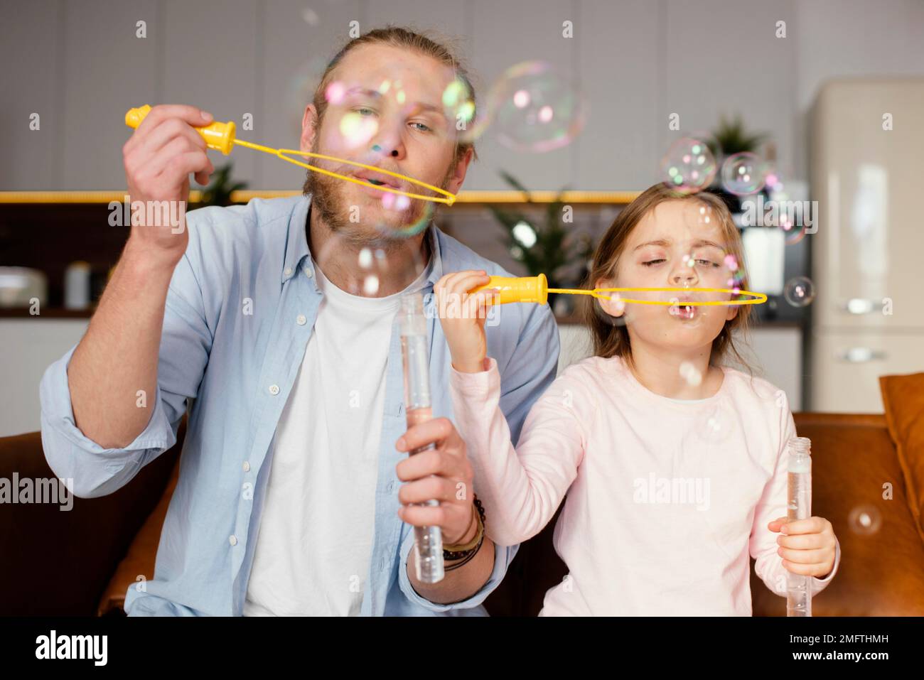 vista frontale padre figlia giocare con bolle di sapone Foto Stock