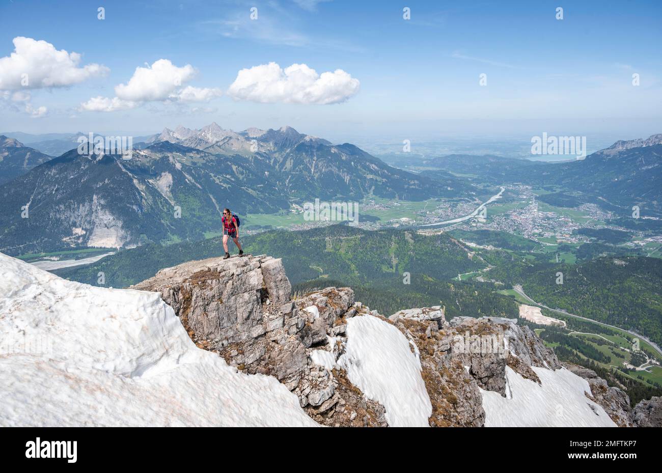 Escursionista a bordo di una roccia, vista da Thaneller, Alpi Lechtal orientali, Tirolo, Austria Foto Stock