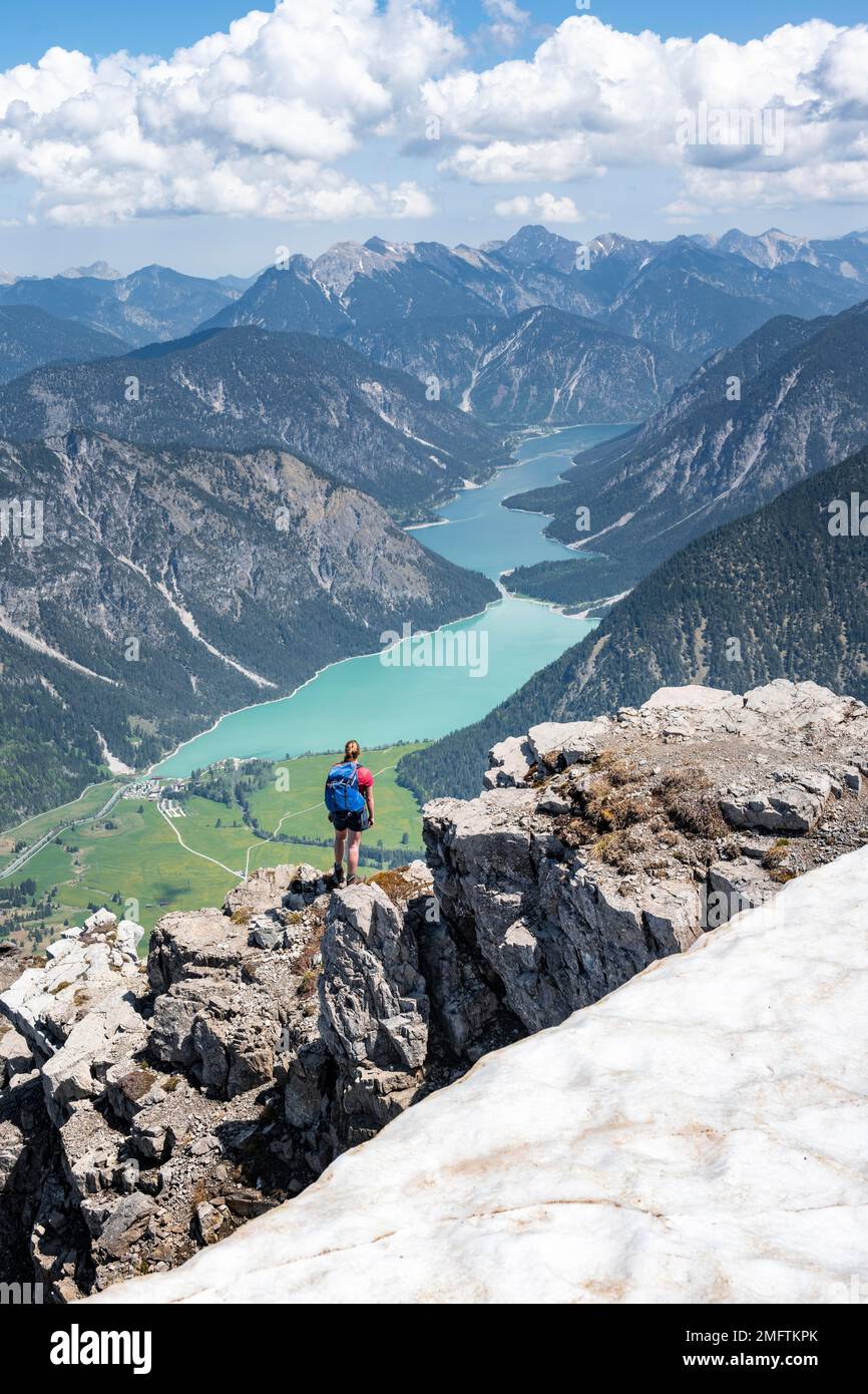 Escursionista a bordo di una roccia, vista da Thaneller a Plansee e Alpi Lechtal orientali, Tirolo, Austria Foto Stock