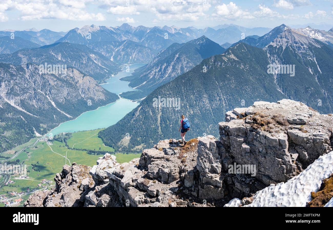 Escursionista a bordo di una roccia, vista da Thaneller a Plansee e Alpi Lechtal orientali, Tirolo, Austria Foto Stock