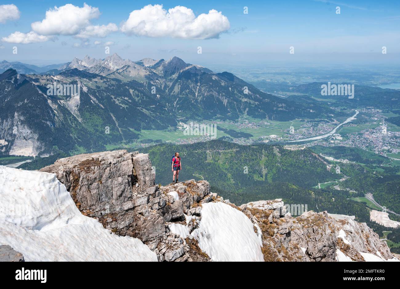 Escursionista a bordo di una roccia, vista da Thaneller, Alpi Lechtal orientali, Tirolo, Austria Foto Stock