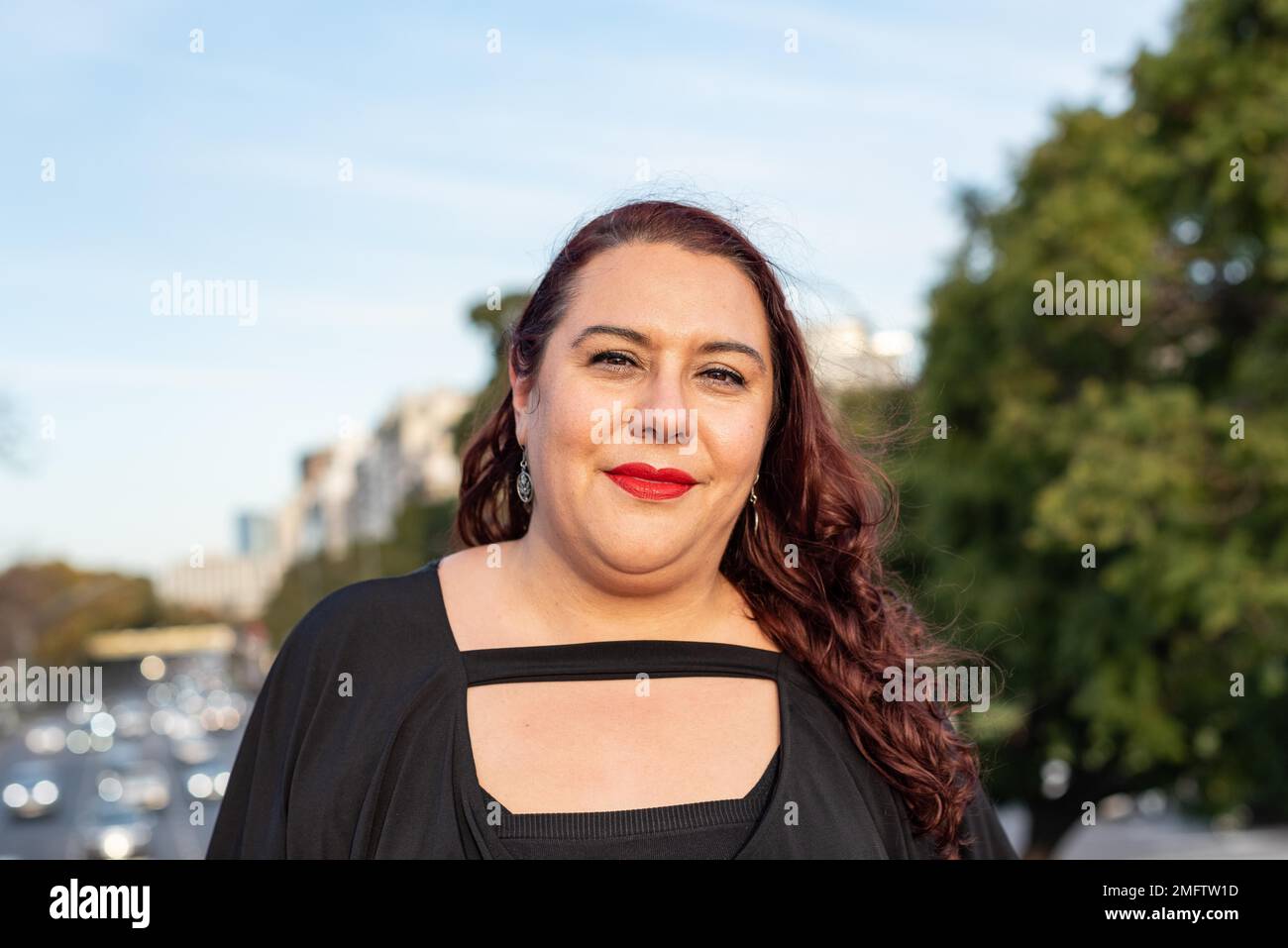 Ritratto di una donna sorridente più-size che guarda la macchina fotografica Foto Stock