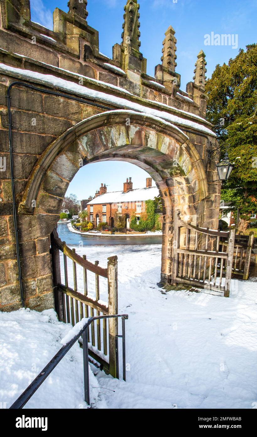 Vista dalla chiesa parrocchiale di St Mary coperta di neve ad Astbury vicino a Congleton Cheshire Inghilterra del villaggio verde in inverno Foto Stock