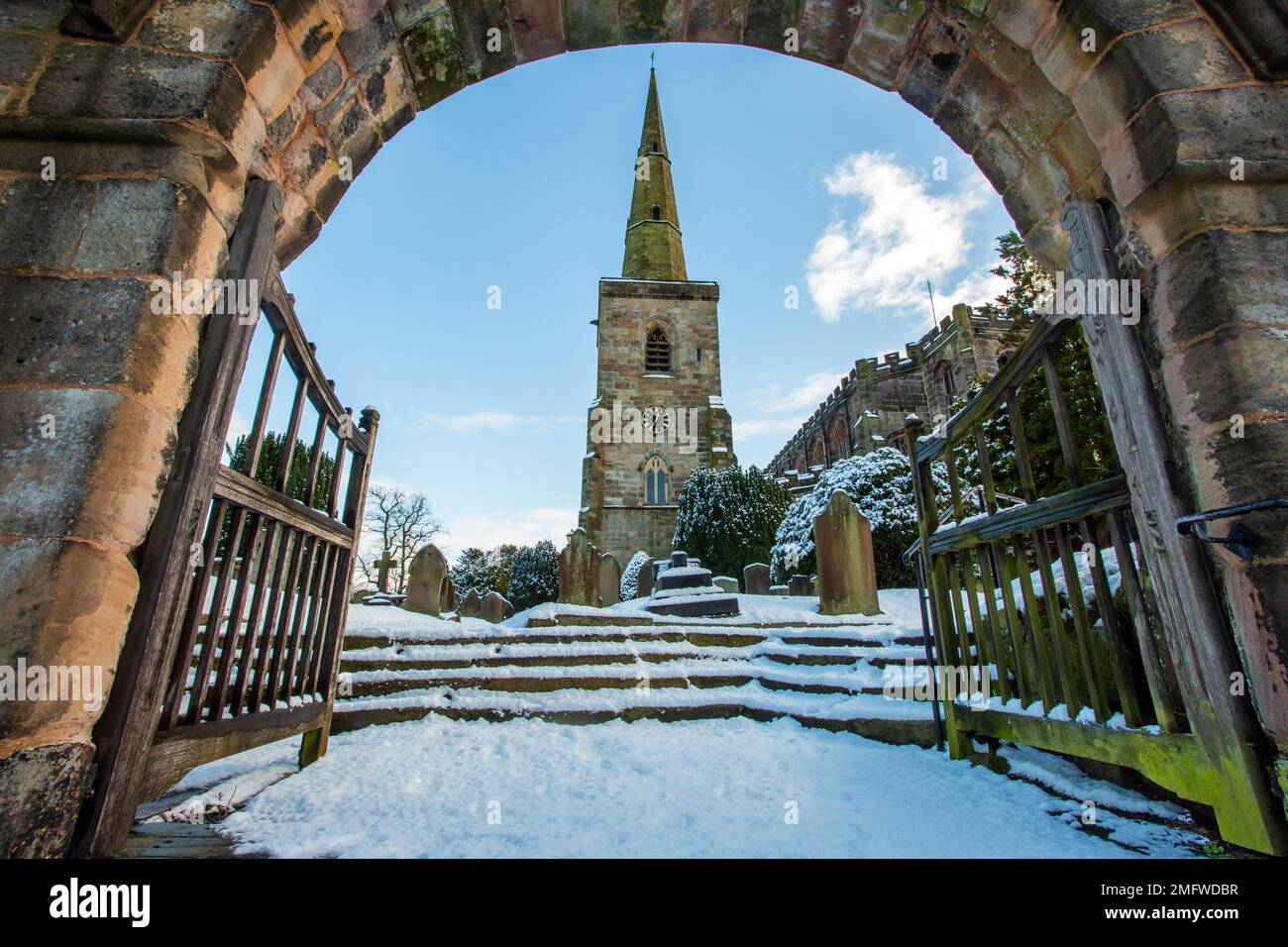 La neve copriva la chiesa parrocchiale di St Mary ad Astbury vicino a Congleton Cheshire Inghilterra dal verde villaggio in inverno Foto Stock