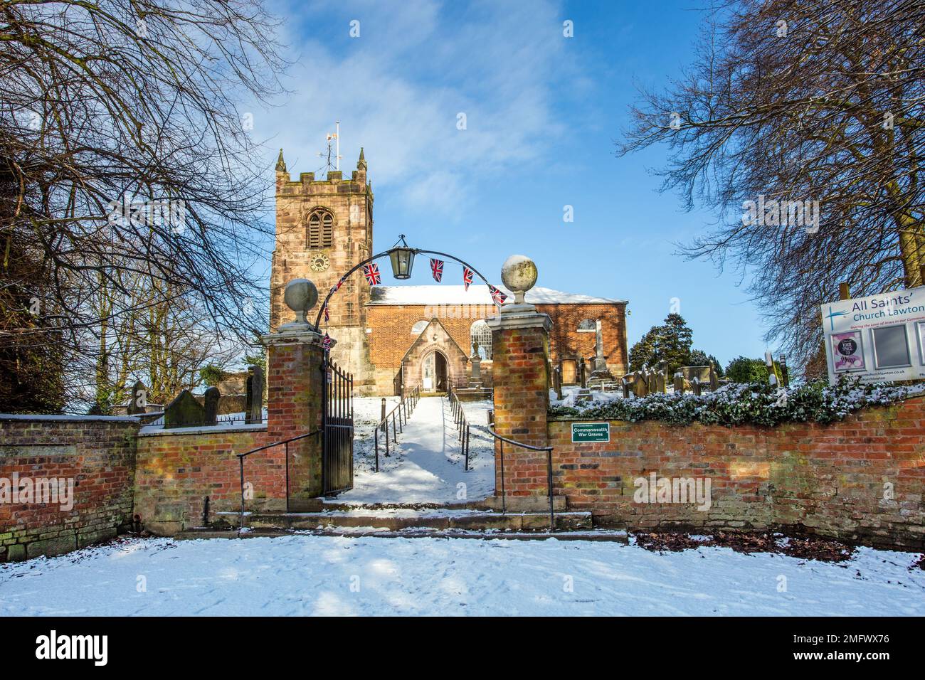 Vista della Chiesa di tutti i Santi nel villaggio di Cheshire di Church Lawton dopo una caduta di neve invernale Foto Stock