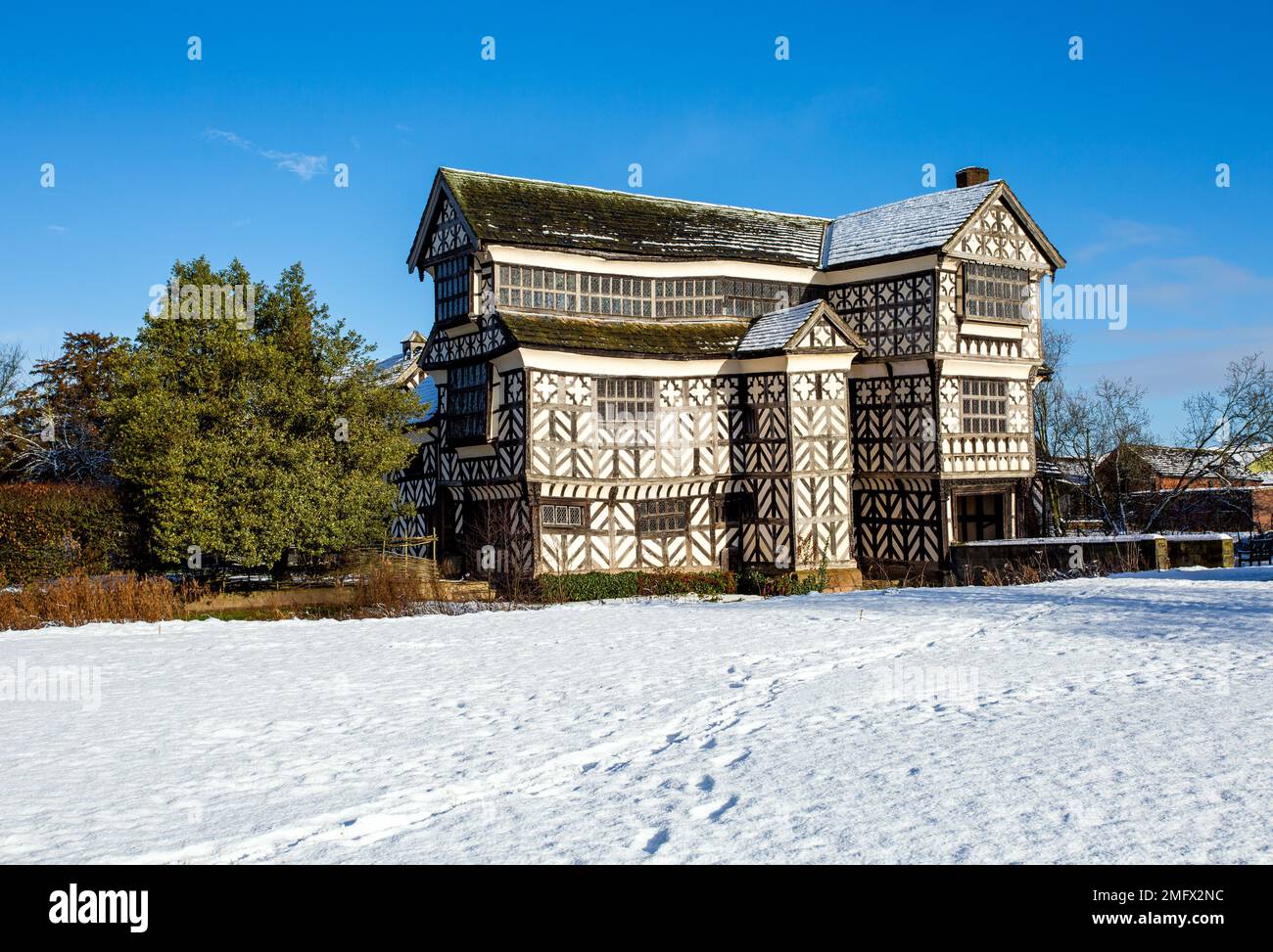 Little Moreton Hall una casa padronale Tudor di proprietà del National Trust vicino a Congleton Cheshire nella neve d'inverno, come visto dal Cheshire sud modo Foto Stock