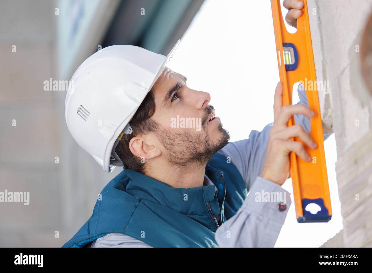 muratore che misura il livello del muro Foto Stock