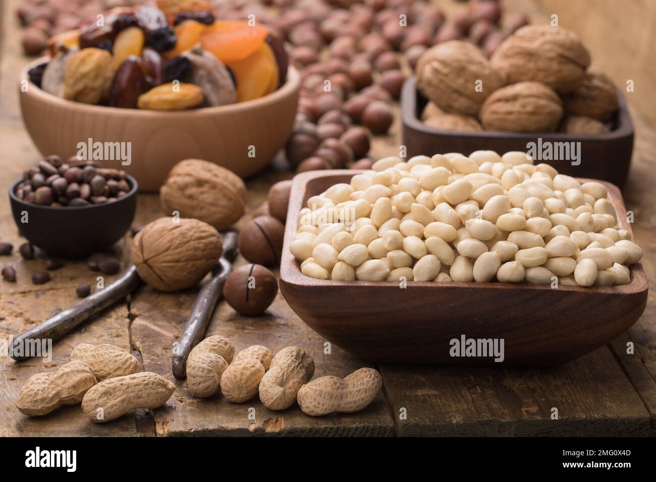arachidi sbucciate in ciotola su tavolo di legno. Alimenti utili per vegetariani e vegani. Foto Stock