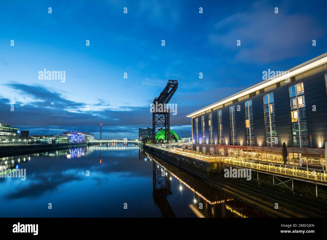 Vista sul fiume Clyde Glasgow di notte con Finnieston Crane e Hilton Garden Inn. Foto Stock