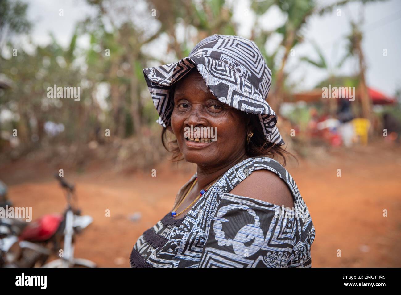 Ritratto di una donna africana matura sorridente vestita con abiti tradizionali e con un cappello Foto Stock