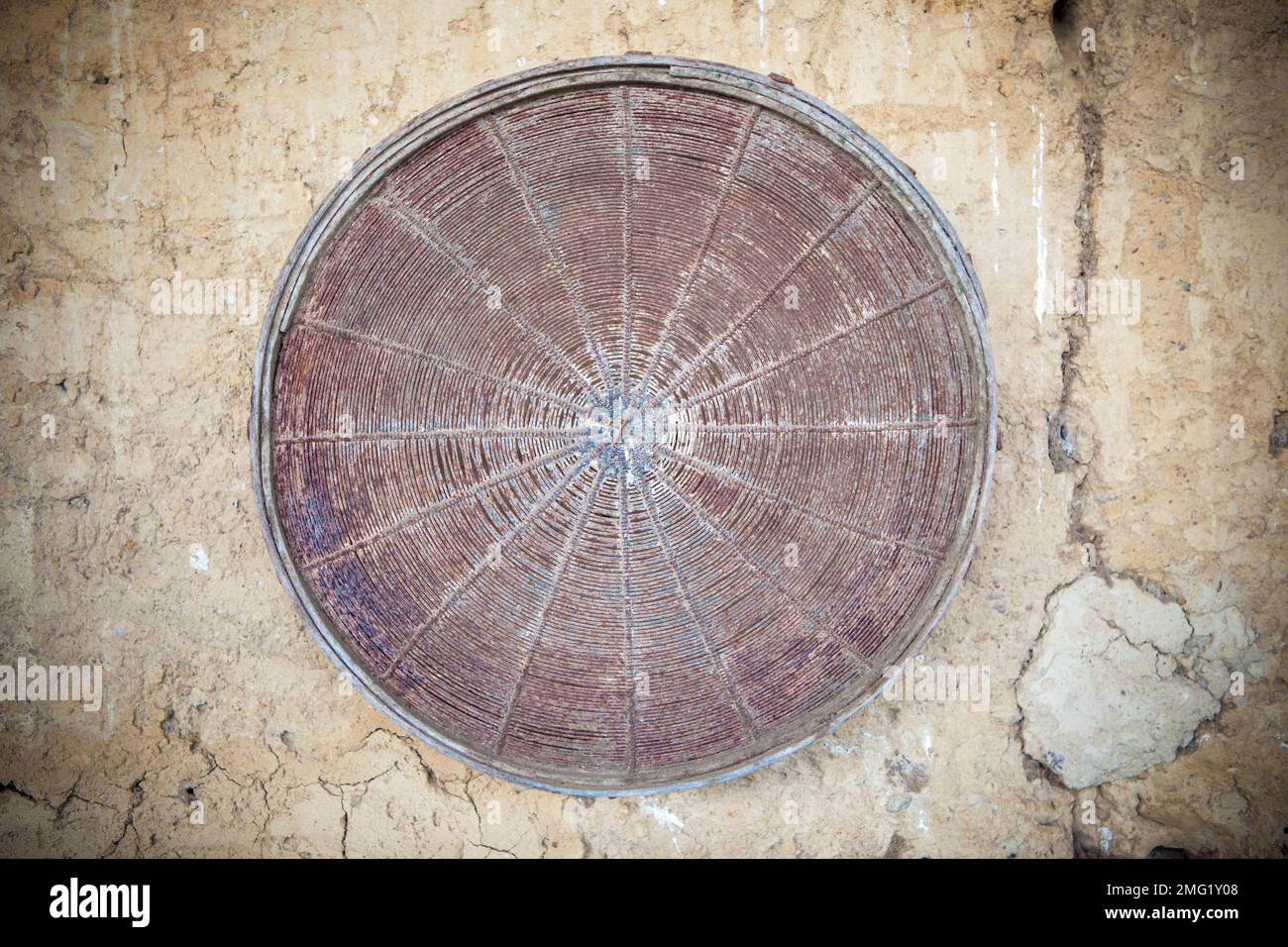 Vecchio setaccio arrugginito attacched sopra muro di adobe fienile. Messa a fuoco selettiva Foto Stock