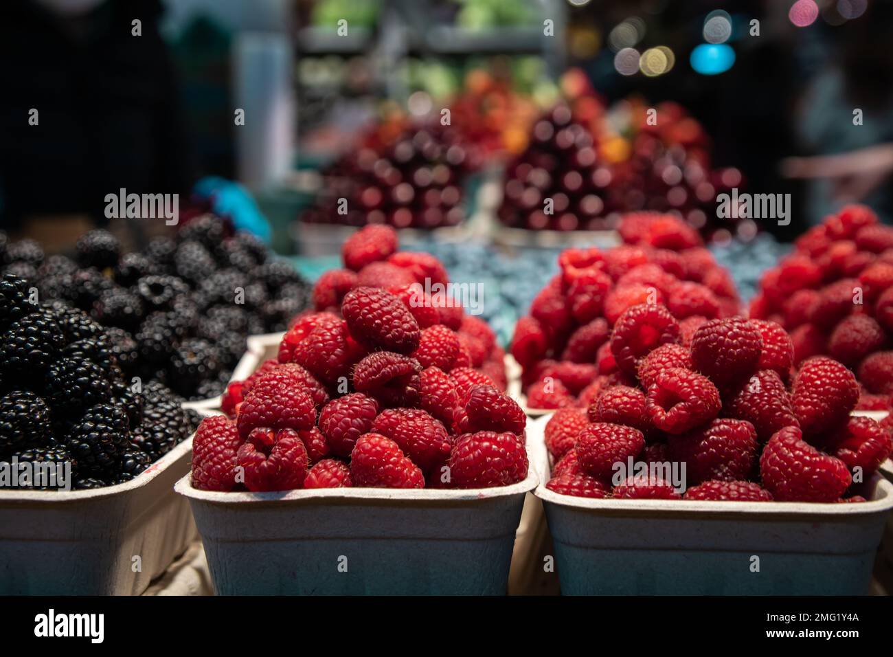 Una confezione di lamponi che vendono in un mercato locale della frutta. Foto Stock