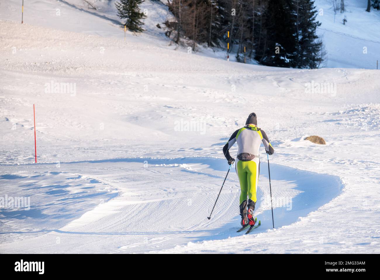 Sciatore di fondo su una pista da sci nelle Alpi in una giornata invernale di sole Foto Stock