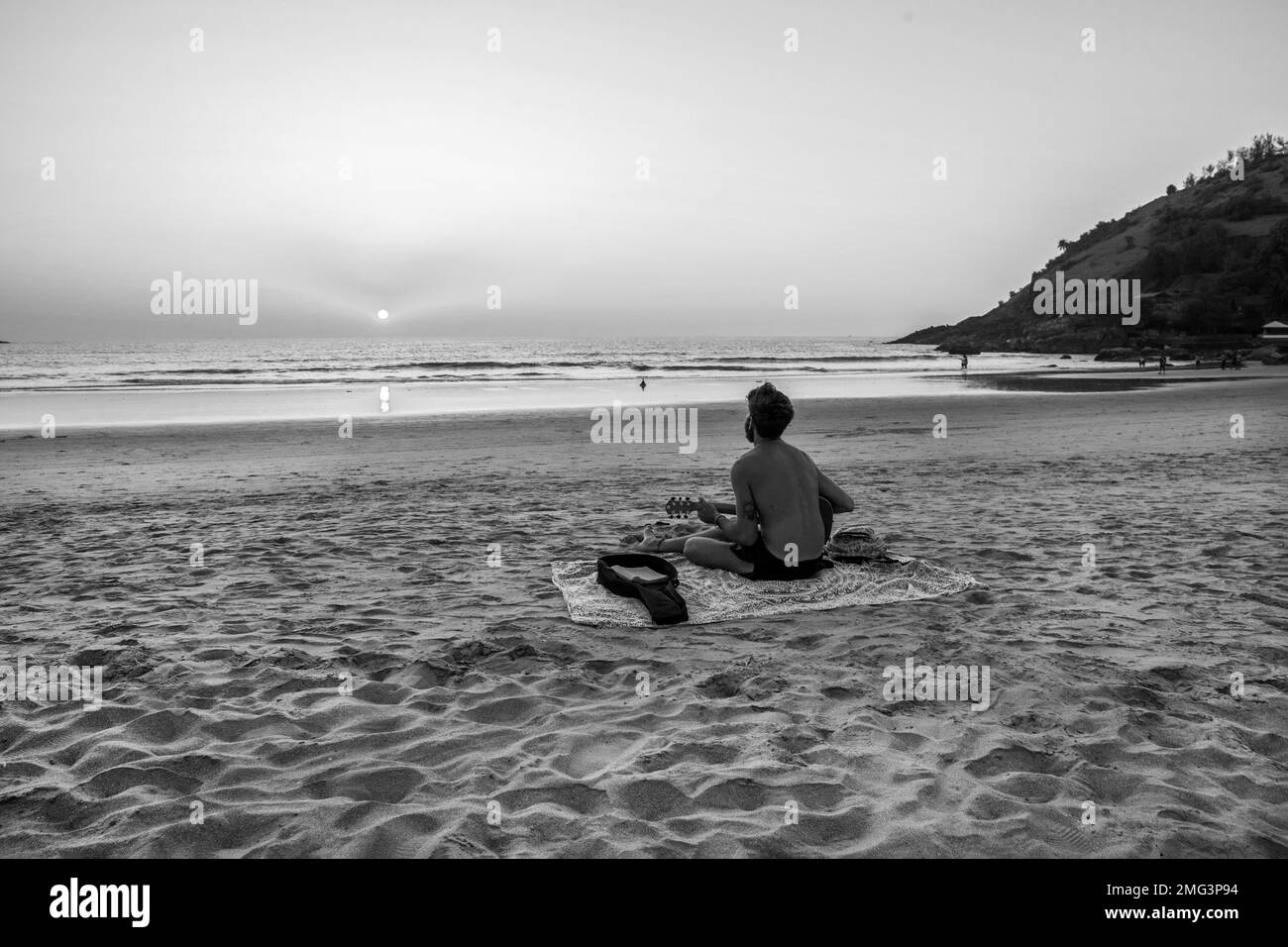 02-19-2019 giovane uomo con chitarra al tramonto o all'alba a Goa (o Kerala, Karnataka) sulla sabbia - incredibile paesaggio con spiaggia. Buon posto se volete Foto Stock