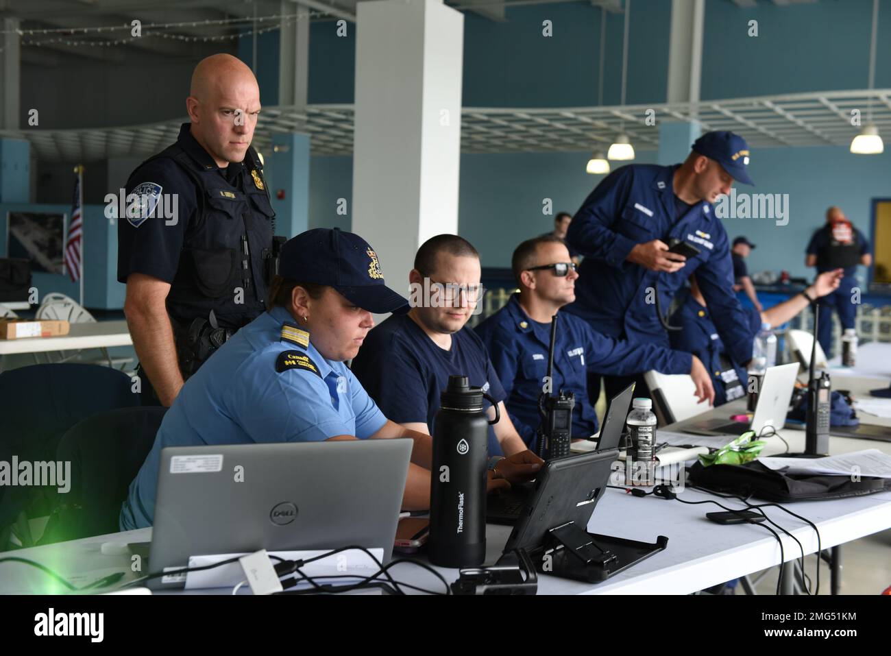 Un funzionario del dipartimento di polizia di Port Huron con i guardiani della costa degli Stati Uniti e del Canada presso un Unified Command Post si è formato per il Float Down on the St. Clair River a Port Huron, Michigan 21 agosto. Il posto di comando unificato multiagenzia è stato creato per rispondere in modo rapido ed efficace ai casi durante l'evento. Foto Stock