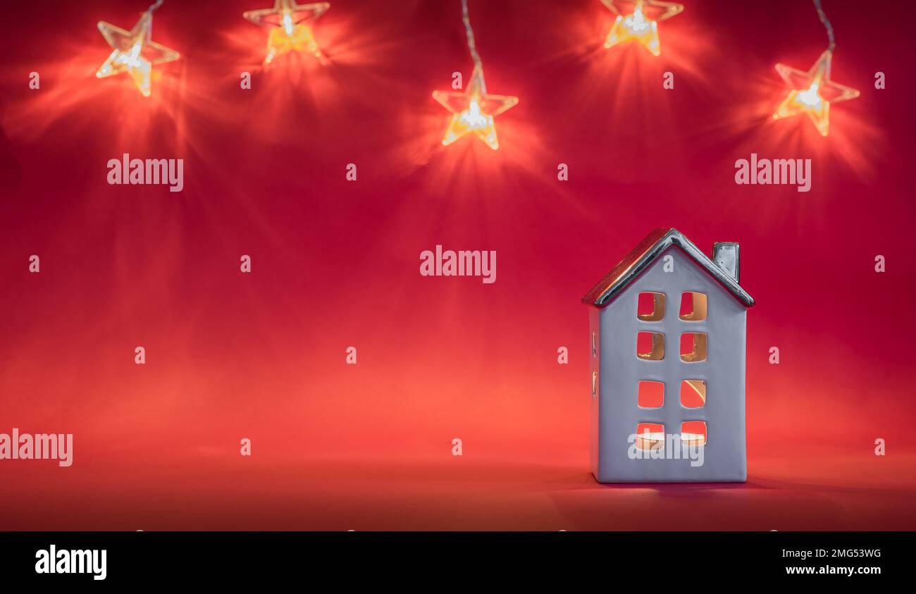 Decorazione della casa di Natale con luce di candela su sfondo rosso. Decorazione per le vacanze. Serie di luci a forma di stella. Foto Stock