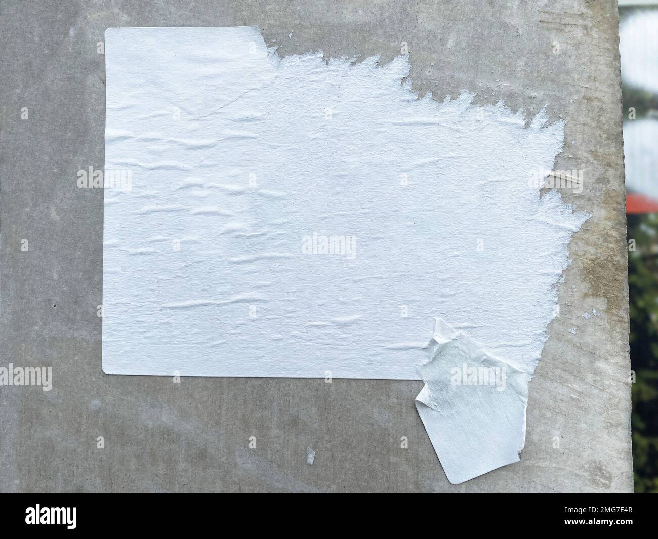 Un poster a muro vuoto con avviso e intemperie si stacca da una parete di cemento Foto Stock