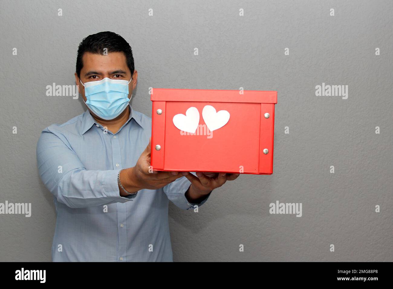 San Valentino: Uomo latino con maschera di protezione e scatola