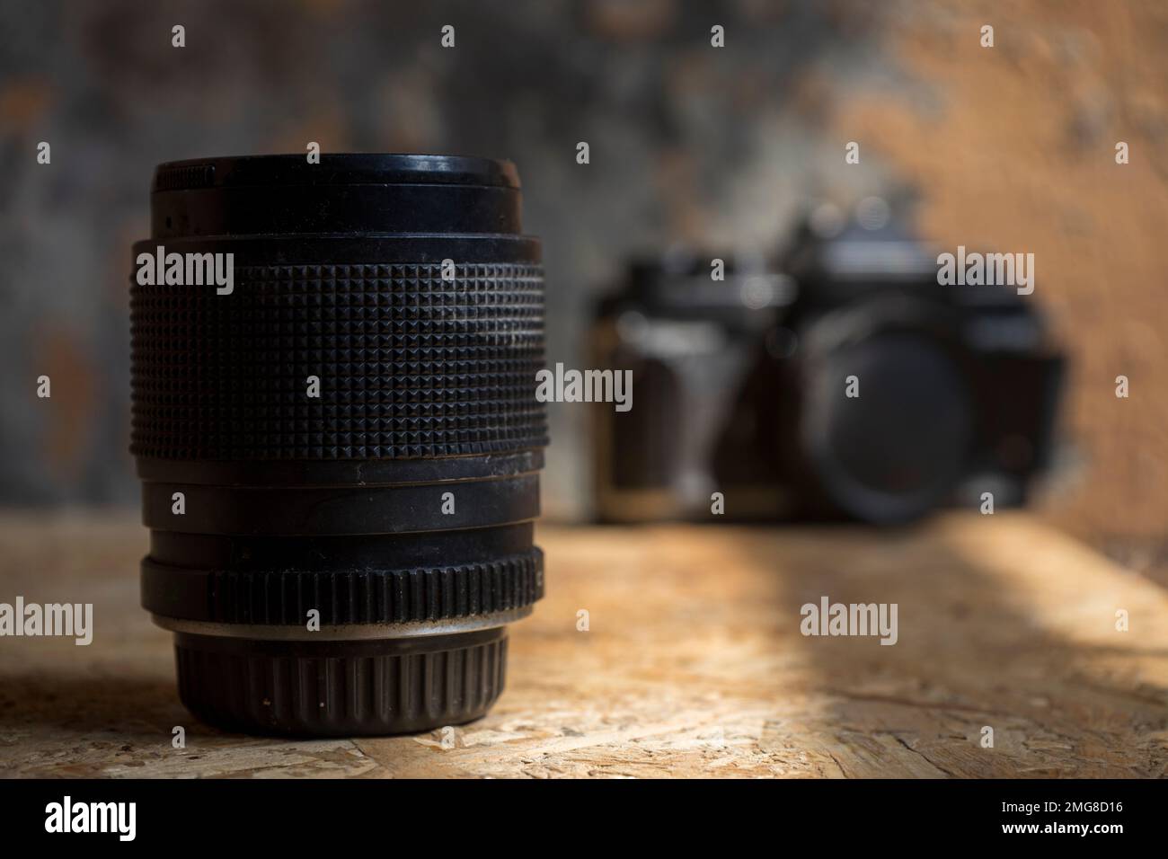 Fotocamera con obiettivo vecchio su sfondo sfocato per uno sfondo artistico dal design retrò Foto Stock