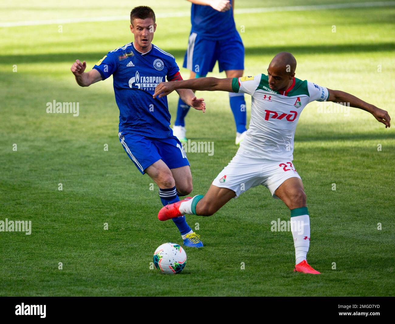 Lokomotiv Moscow's Joao Mario, right, challenges for the ball with Orenburg's Andrei Malykh during the Russia Soccer Premier League soccer match between Lokomotiv Moscow and Orenburg, resumed after a three-month hiatus because of the coronavirus pandemic, at Lokomotiv stadium in Moscow, Russia, Sunday, June 21, 2020. The match is being played with a minimum spectators to curb the spread of COVID-19. (AP Photo/Alexander Zemlianichenko) Foto Stock