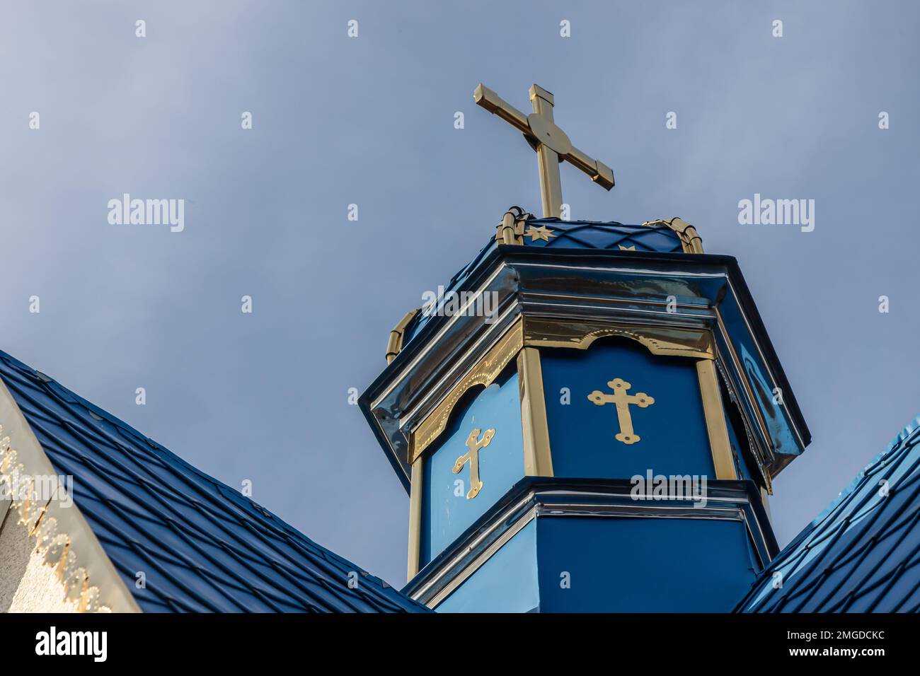 Primo piano di una Croce su una chiesa cristiana su sfondo blu. Foto Stock