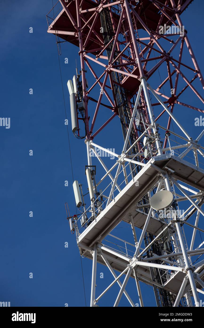 Antenna per telecomunicazioni per radio, televisione e telefonia con nuvola e cielo blu. Foto Stock