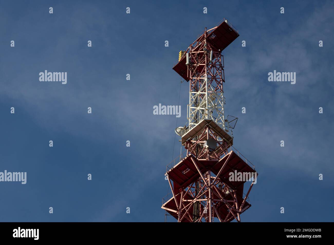 Antenna per telecomunicazioni per radio, televisione e telefonia con nuvola e cielo blu. Foto Stock