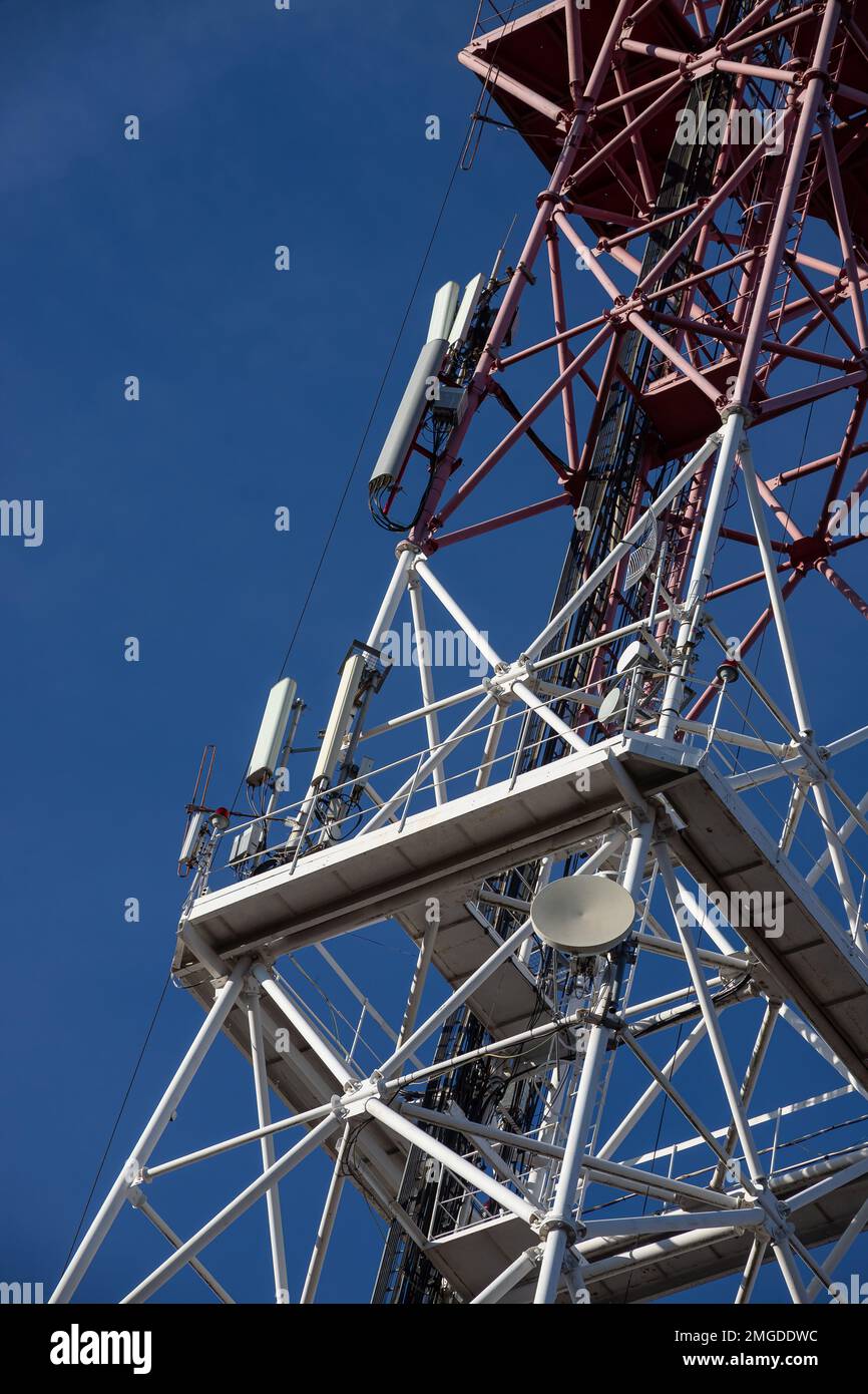 Antenna per telecomunicazioni per radio, televisione e telefonia con nuvola e cielo blu. Foto Stock