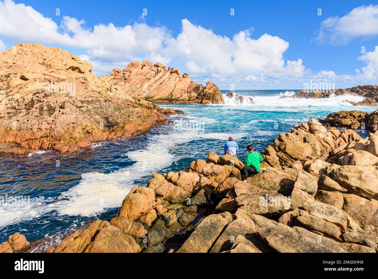 Persone che guardano il picco di marea d'acqua attraverso lo stretto canale di granito di Canal Rocks, Leeuwin-Naturaliste National Park, Australia Occidentale Foto Stock