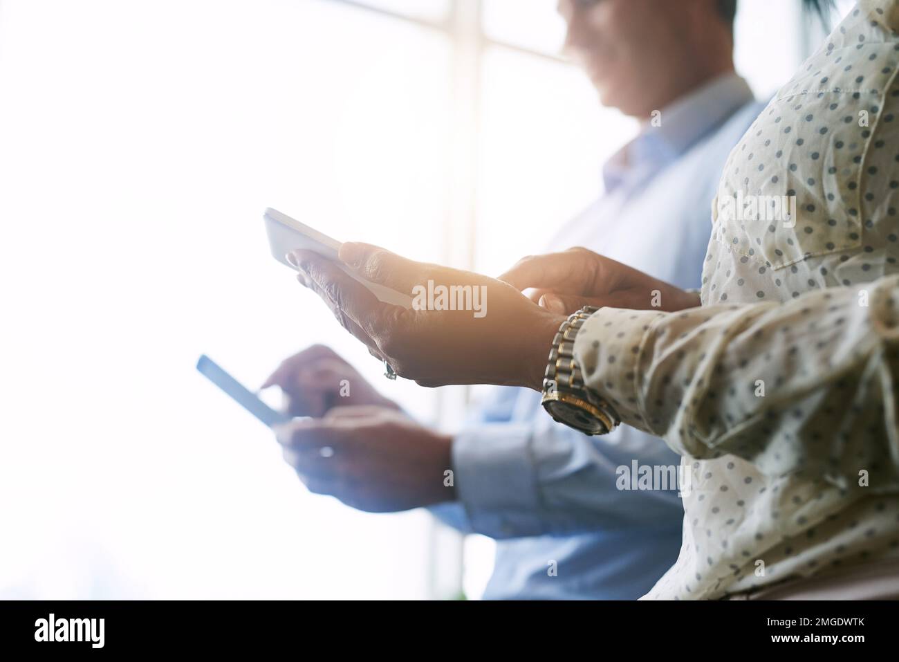Creazione di connessioni intelligenti. Primo piano di due uomini d'affari irriconoscibili che utilizzano dispositivi digitali in un ufficio. Foto Stock