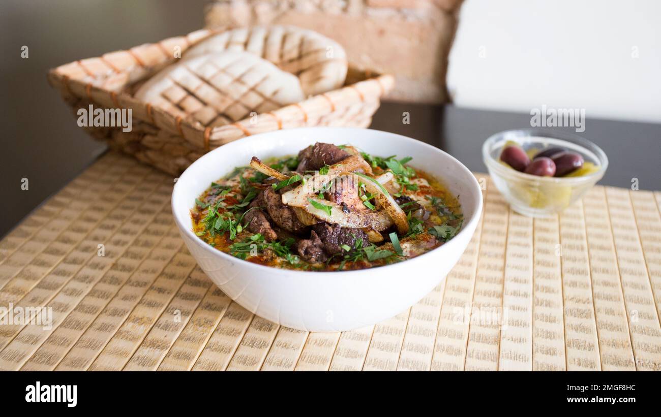 Ciotola con hummus e agnello servito con pane pita. Foto Stock
