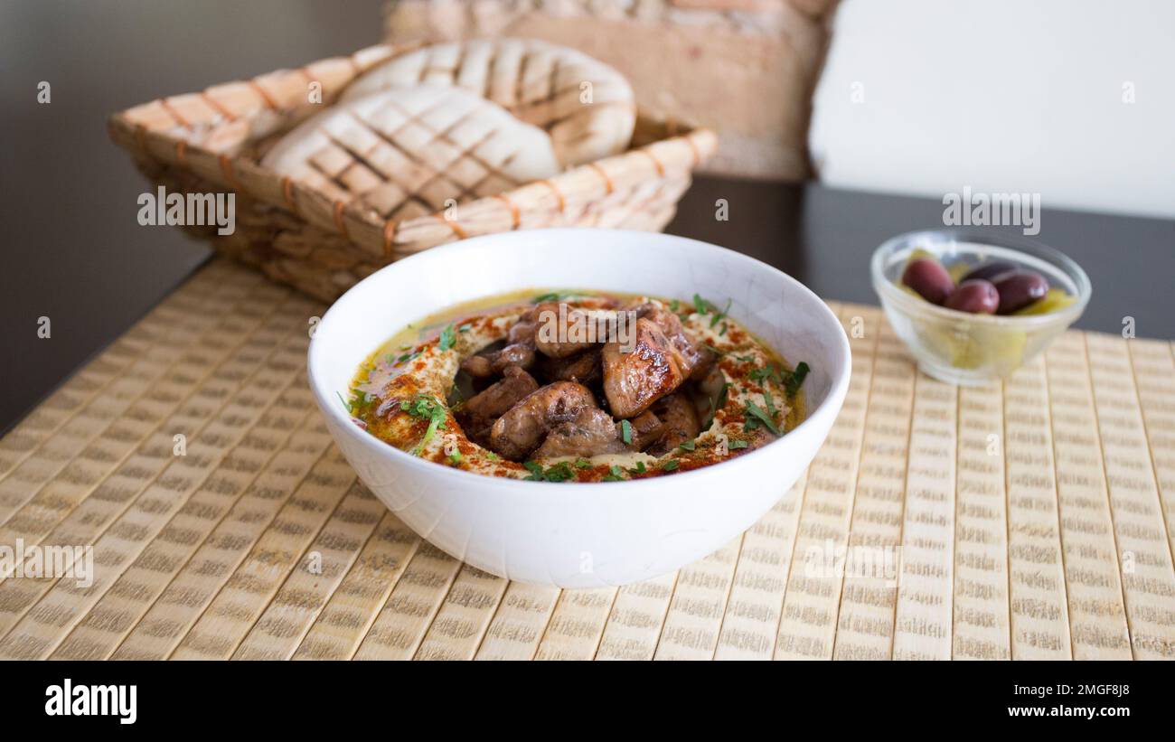 Ciotola con hummus e agnello servito con pane pita. Foto Stock