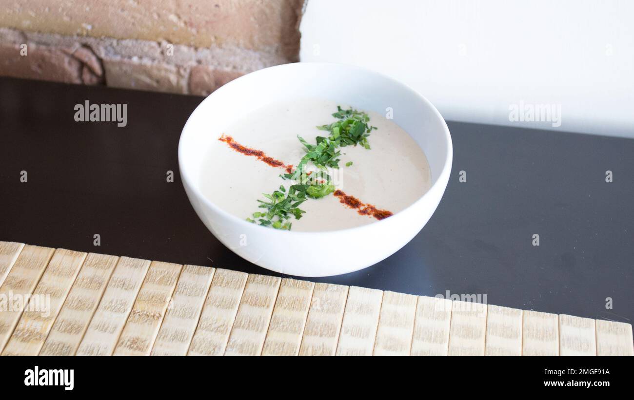 Il tahini o tahini è una pasta fatta dai semi di sesamo macinati che è usato come ingrediente in vari piatti mediorientali. Foto Stock