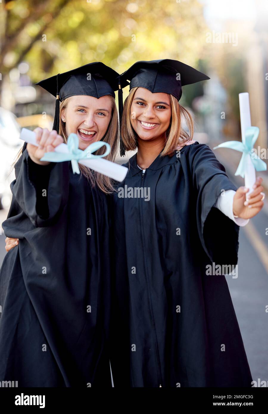 Laurea, educazione e ritratto di amici con laurea per il successo accademico presso il campus universitario. Certificato, successo e giovani donne felici Foto Stock