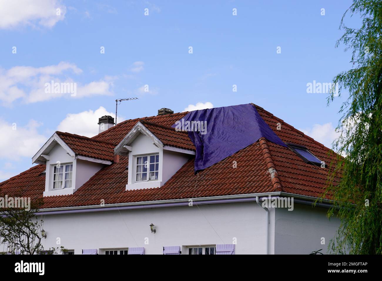 il tetto necessita di riparazioni coperte con un telone in attesa che la società di copertura ripari dopo la tempesta estiva di primavera Foto Stock