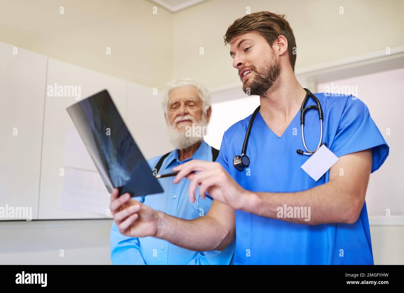 Guardate cosa ho trovato sulla vostra radiografia. un giovane medico e il suo paziente anziano che guarda una radiografia insieme. Foto Stock