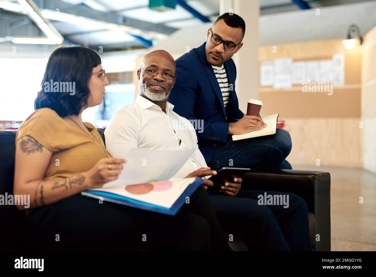 Unendo insieme le loro competenze e competenze uniche. un gruppo di designer che discuterà in un ufficio. Foto Stock
