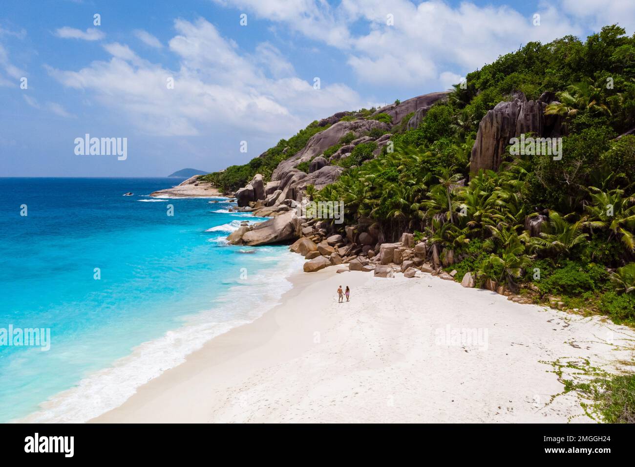 Uomini e donne che camminano in una spiaggia tropicale, vista da drone dall'alto Seychelles Cocos Island. Foto Stock