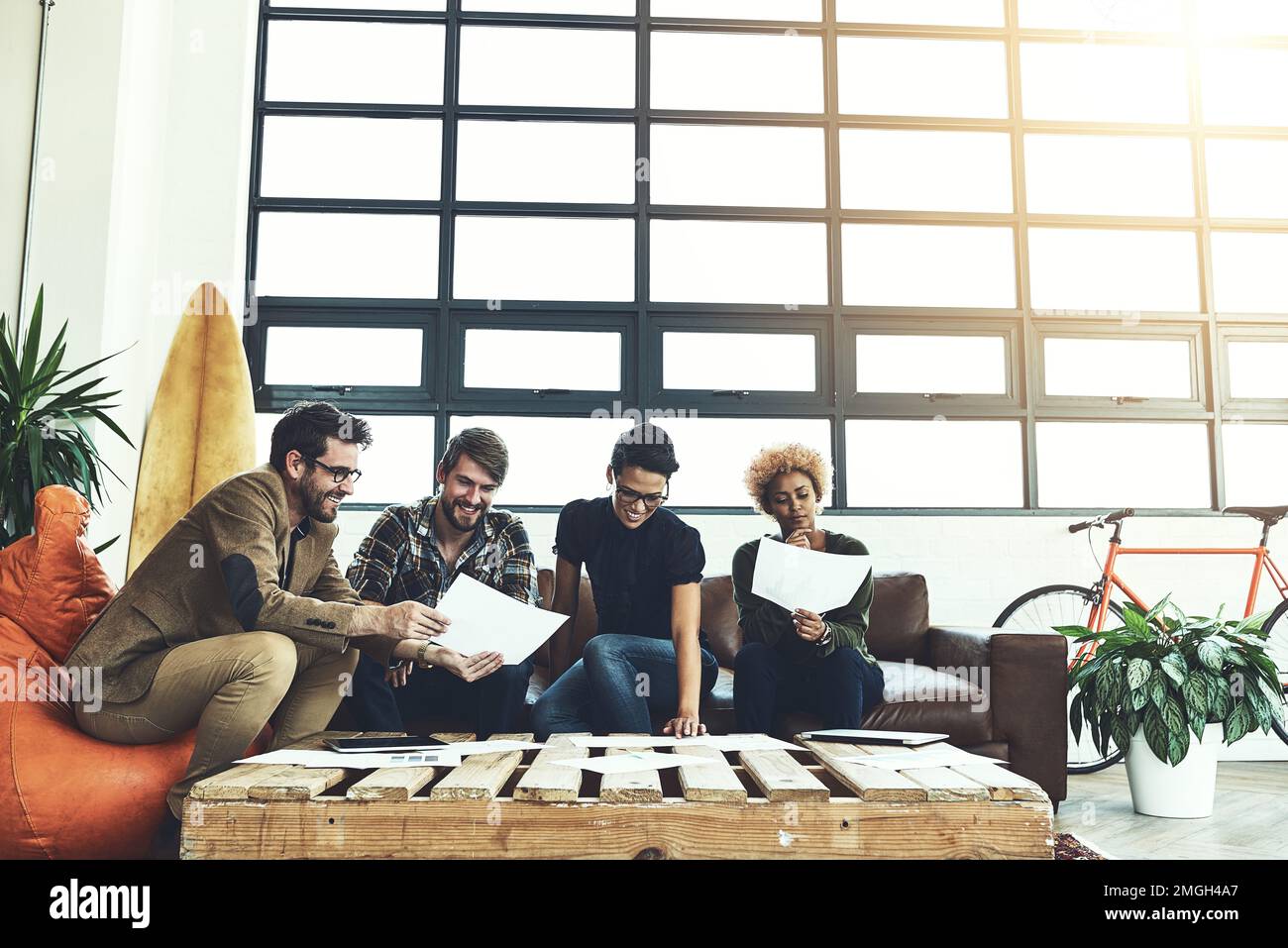 Scavare in profondità. un gruppo di giovani designer che discutono di documenti. Foto Stock