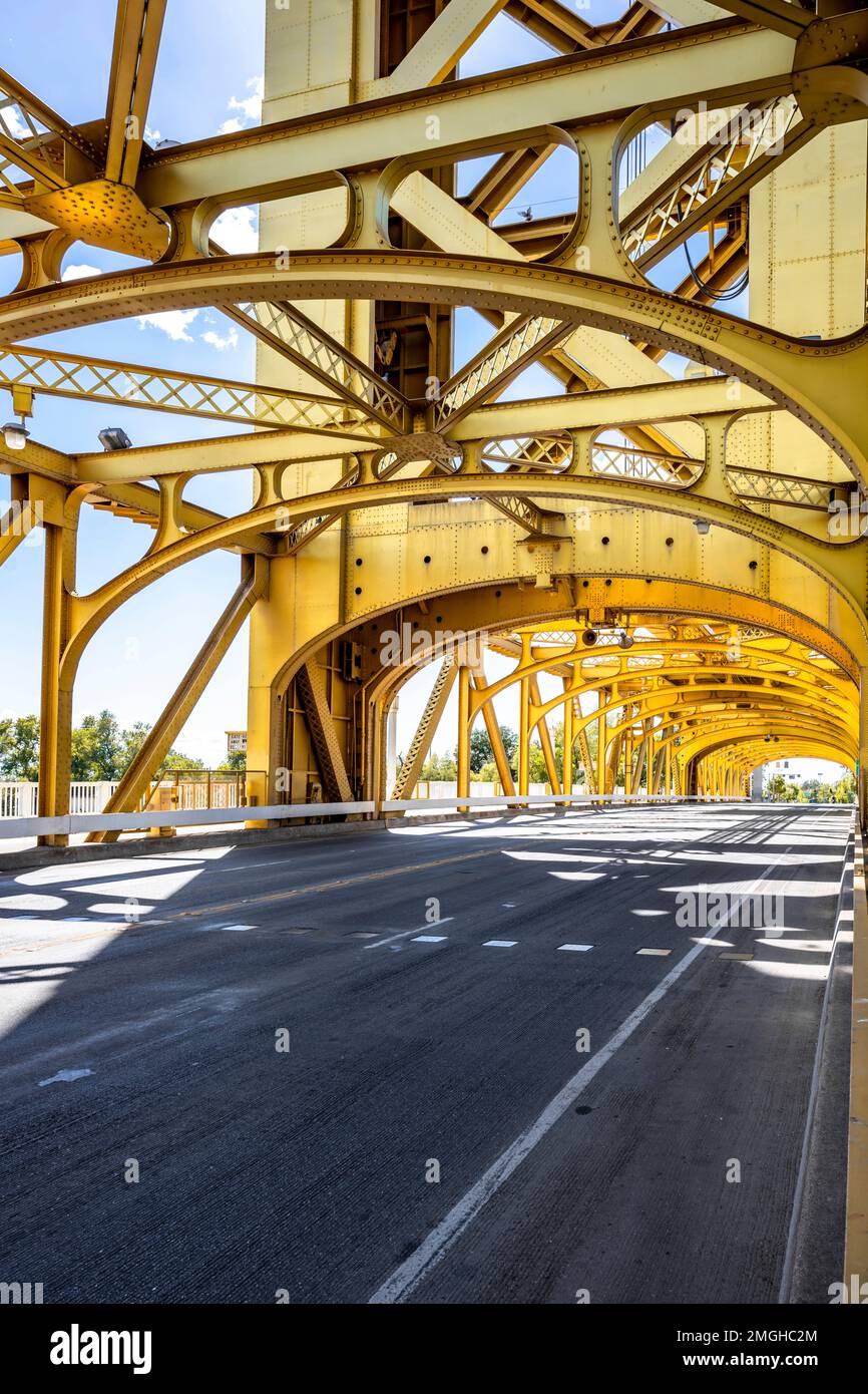 A capriate arcuate pedonale e trasporto Golden Bridge con strada segnata a Sacramento California in luce del sole come simbolo del vecchio archi Foto Stock