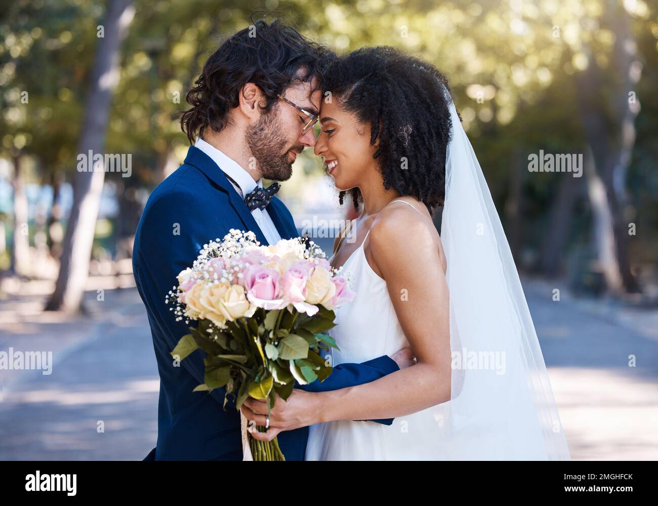 Coppia sposata, fiore bokeh e sorriso per impegno, matrimonio o amore insieme nel parco. Buon sposo e sposa sorridente in felicità per la luna di miele Foto Stock