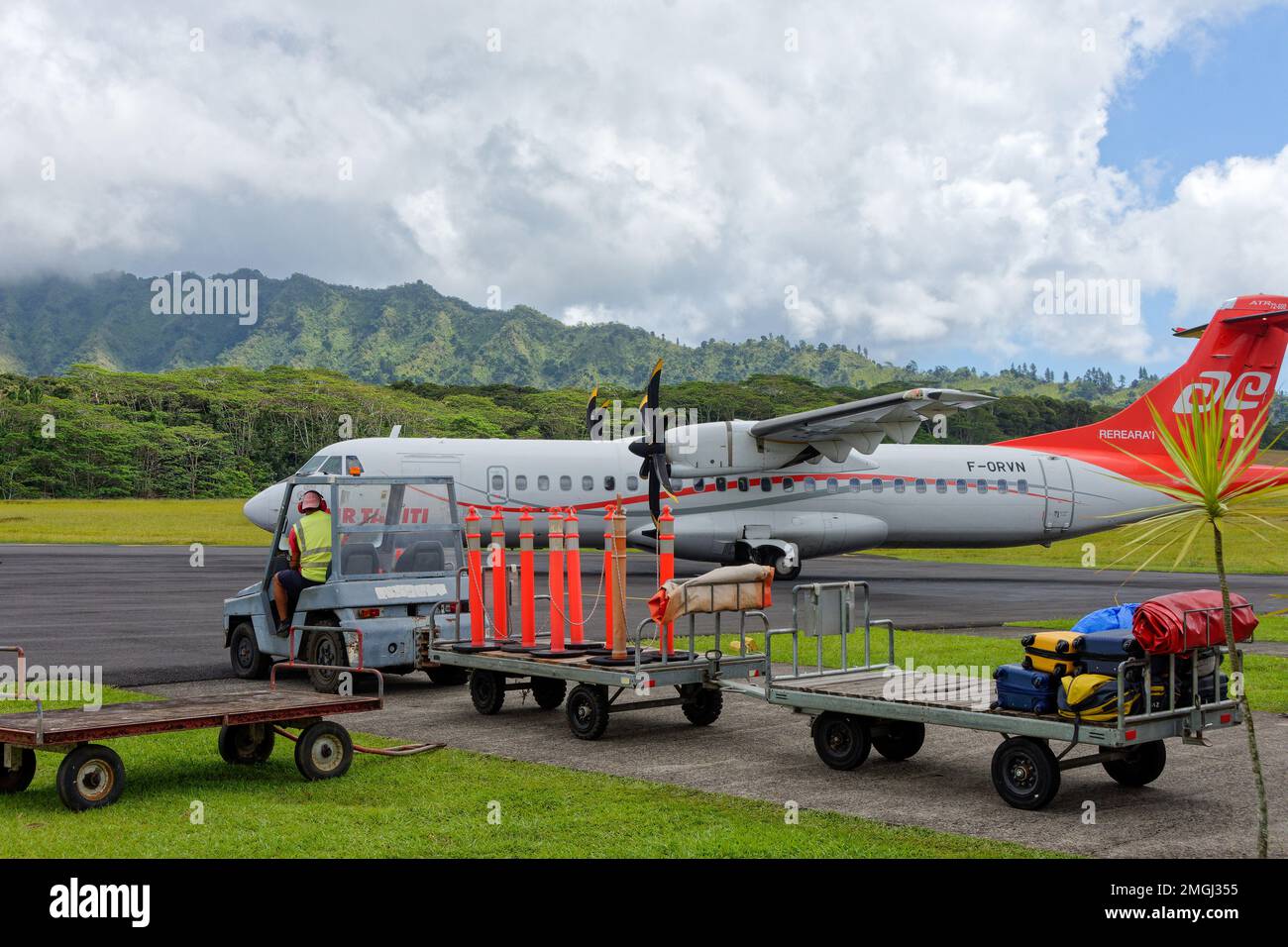 Polinesia Francese, Hiva Oa: Aeroporto di Atuona o aeroporto di Hiva Oa. Air Tahiti ATR linea aerea regionale sulla pista di atterraggio e personale a terra con auto bagagli Foto Stock
