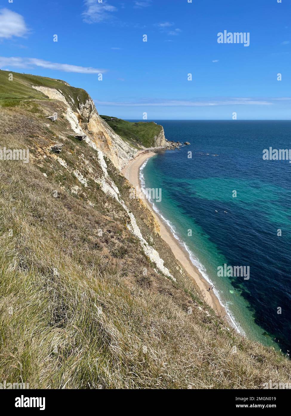 Uno scatto verticale di un bel mare con scogliere boscose Foto Stock