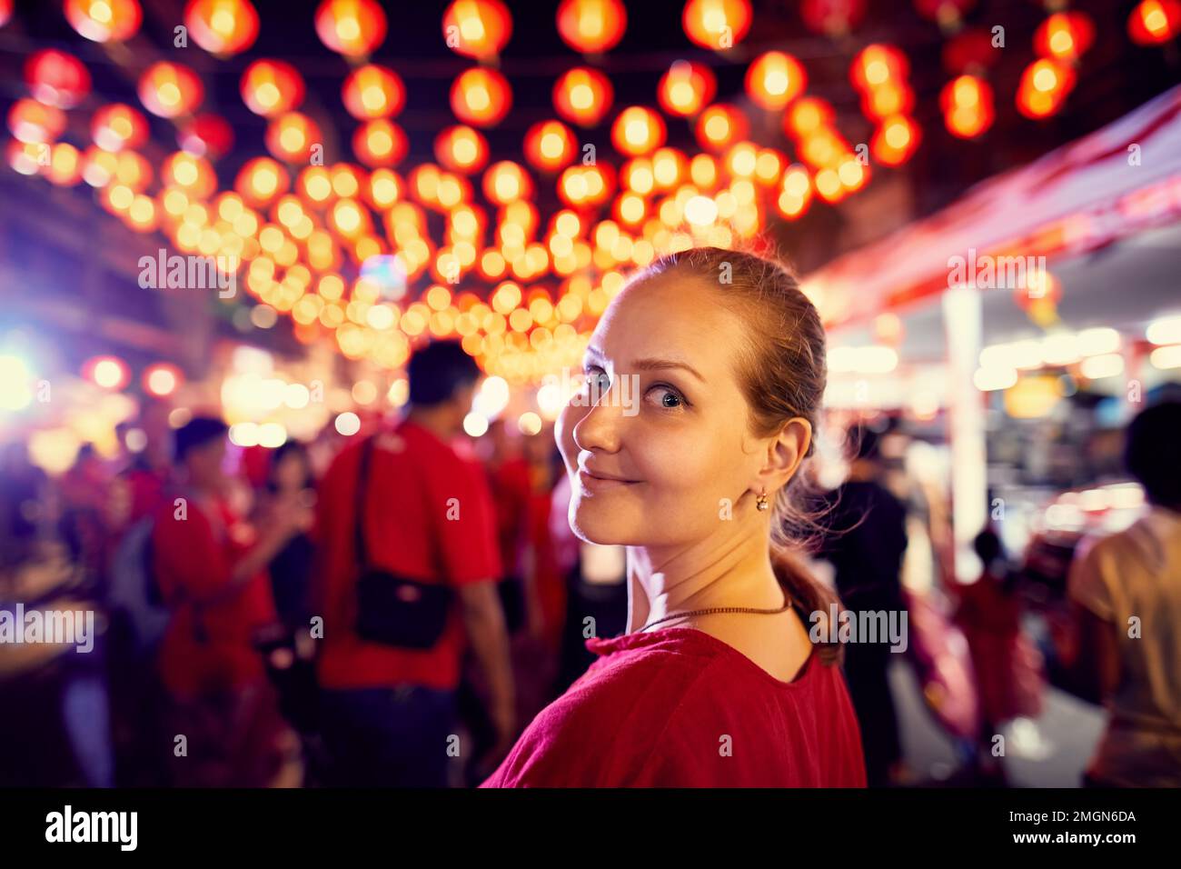 Donna turistica in camicia rossa ritratto vicino alla decorazione del mercato notturno con lanterna rossa luci per il Capodanno cinese a Bangkok Chinatown in Thailandia Foto Stock