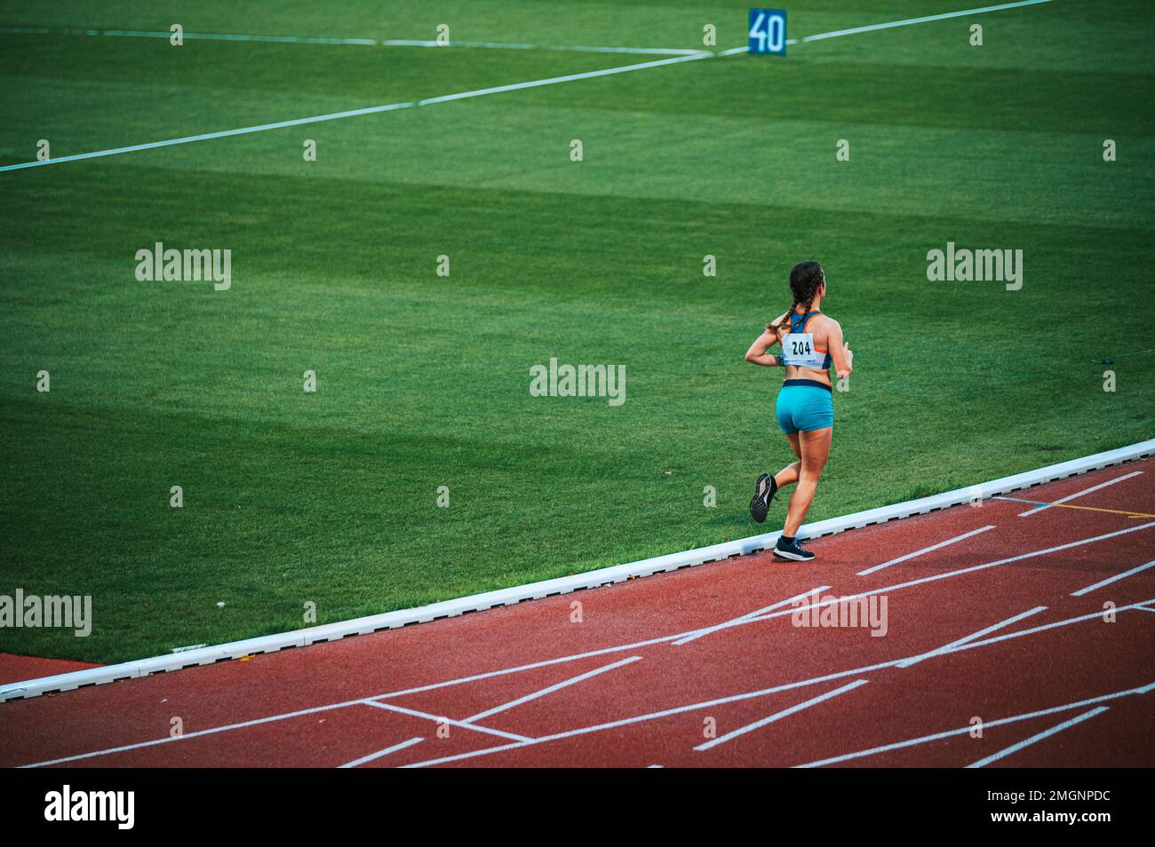 Atleta femminile da sola in pista durante la gara Foto Stock