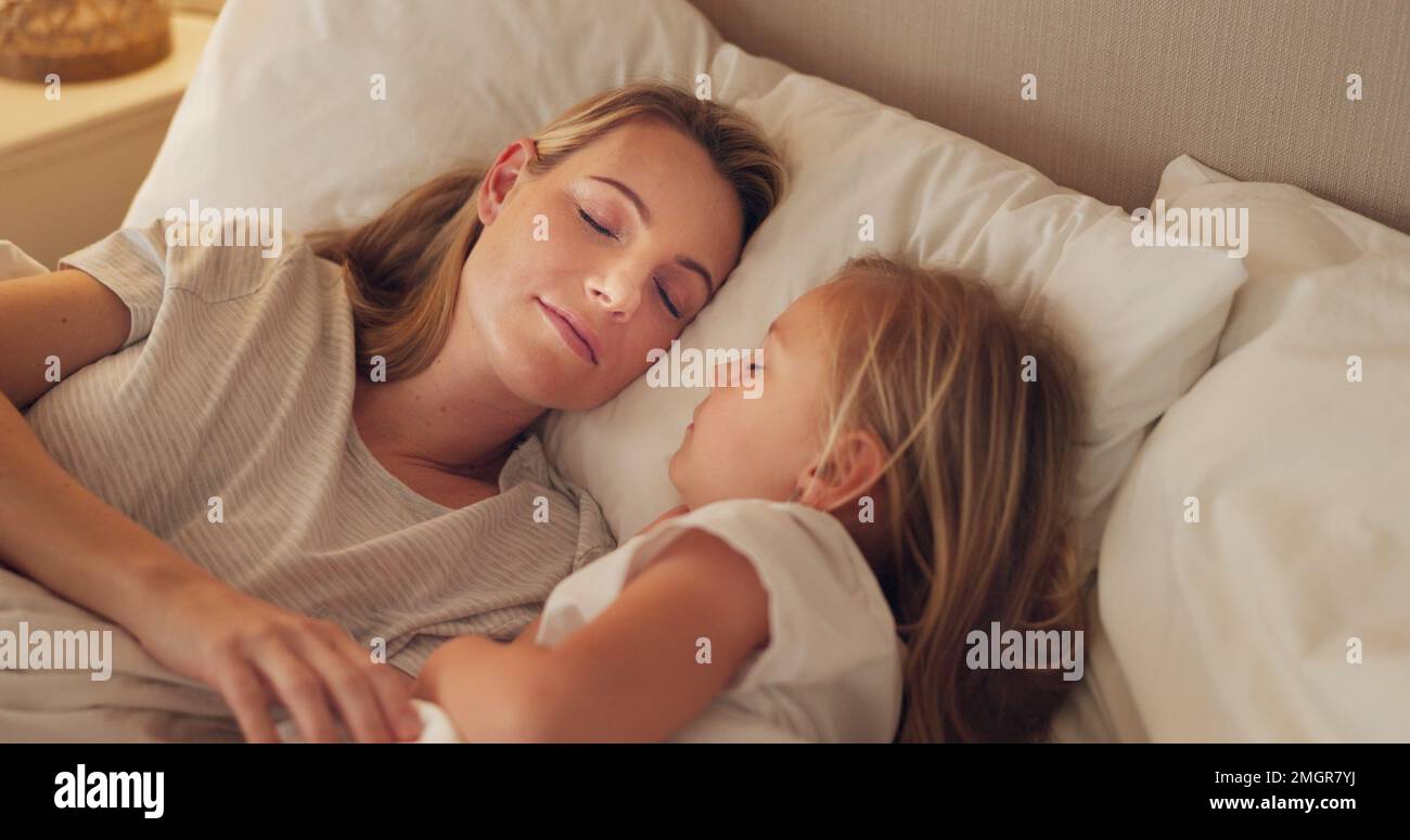 Letto, mamma e bambino rilassarsi dormire insieme a letto, calma e pace in camera da letto di notte in casa. Madre giovane stanca, bambina che dorme e infanzia Foto Stock