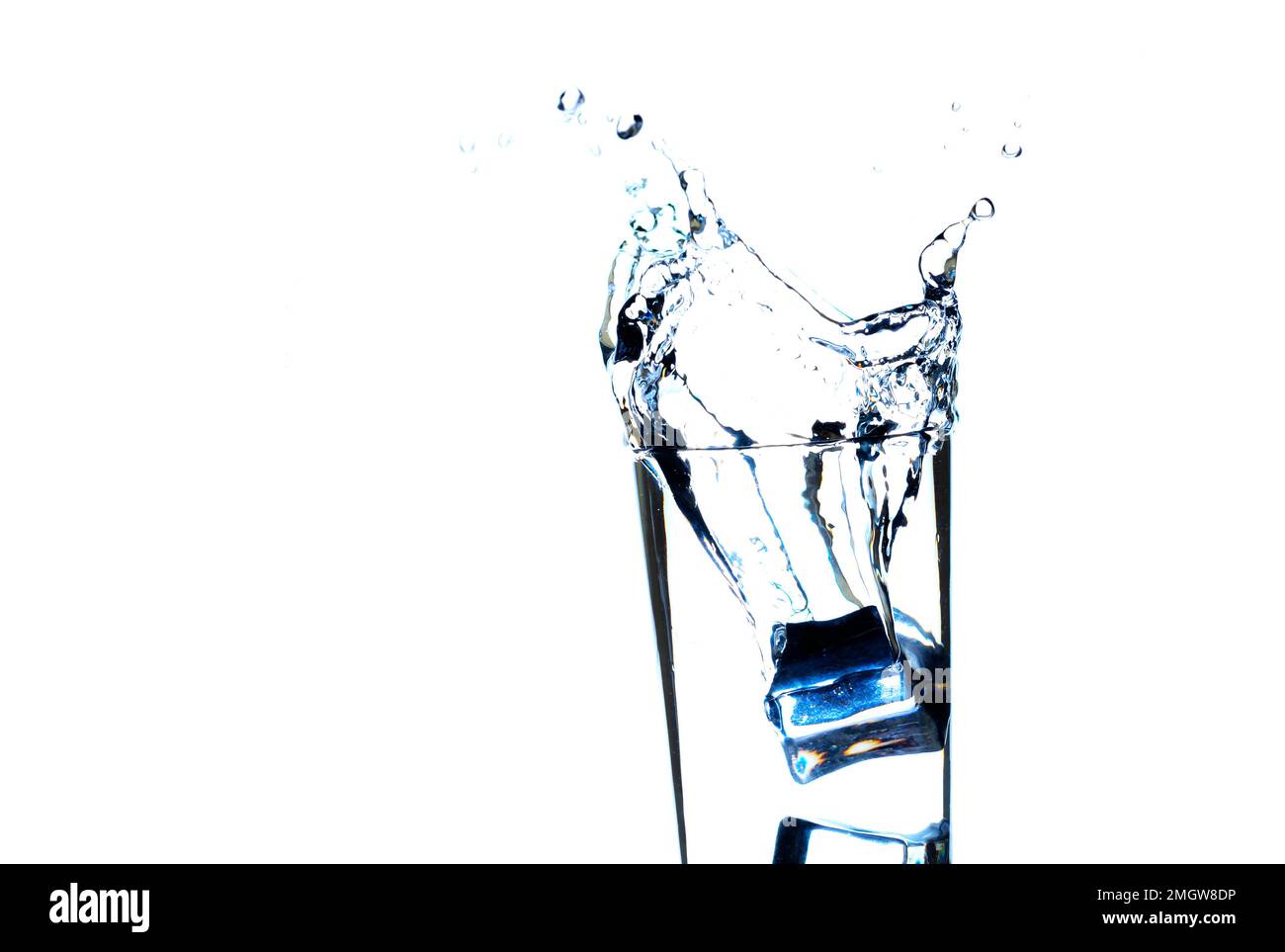 L'immagine di versare acqua potabile, in un bicchiere, che fa sentire rinfrescato su sfondo bianco sfocato, spruzzi d'acqua, acqua frizzante Foto Stock