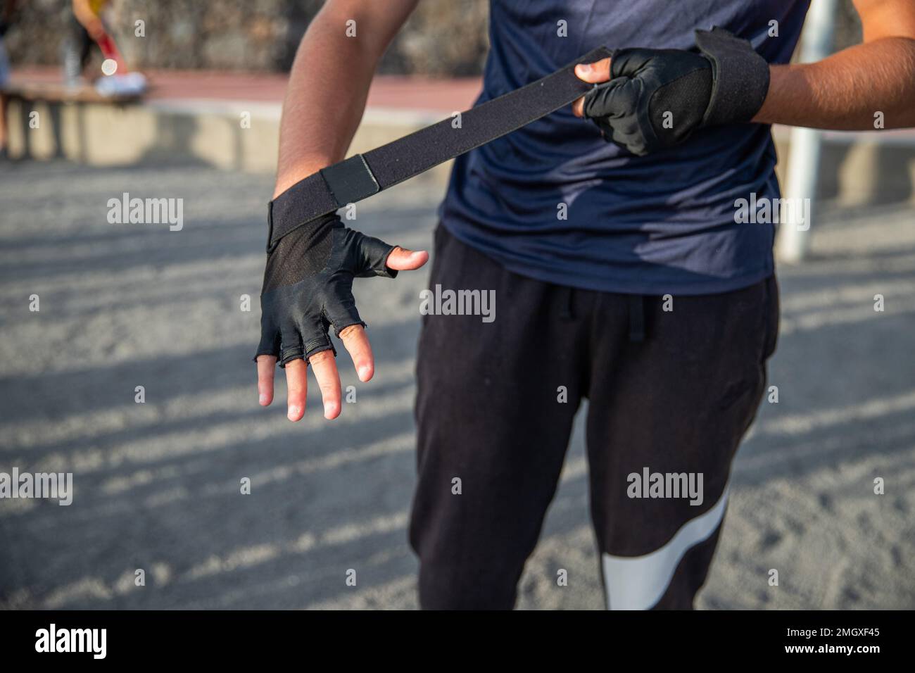 Primo piano della mano di un atleta indossando guanti protettivi per allenarsi in palestra Foto Stock