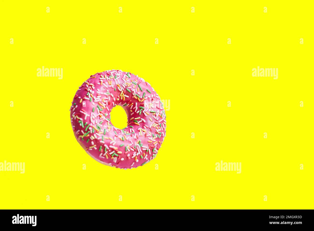 Ciambella rosa su sfondo giallo. Spazio per il testo Foto Stock